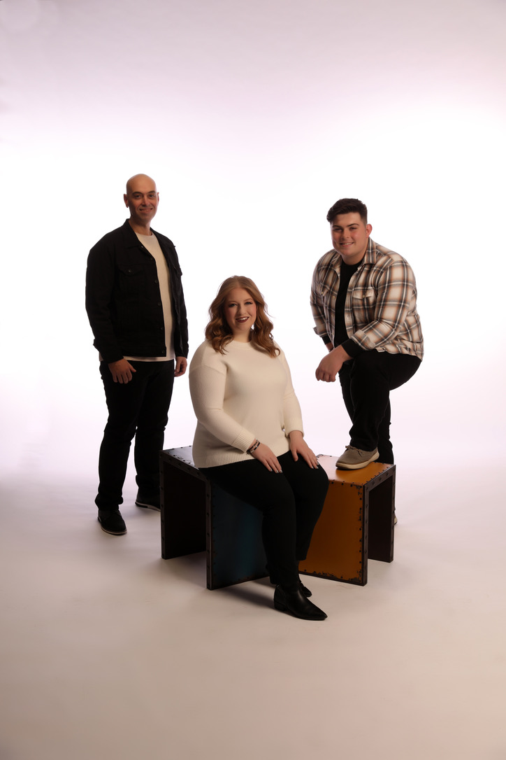 Chad, Caitlyn, and Caleb in the studio with orange and black cubes